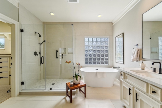 full bath featuring a wealth of natural light, a freestanding bath, tile patterned flooring, and a stall shower