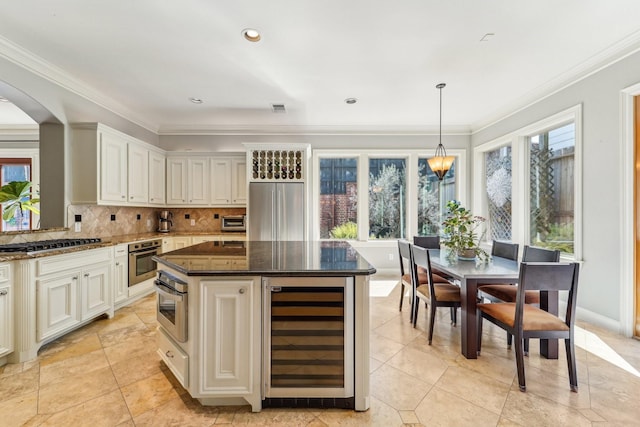 kitchen with backsplash, wine cooler, a healthy amount of sunlight, stainless steel appliances, and arched walkways