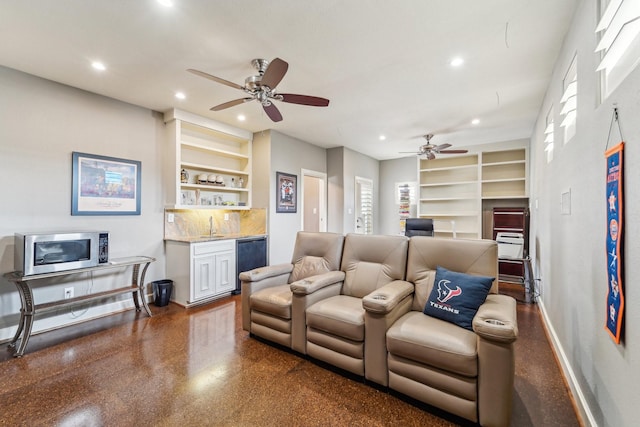 living room with built in shelves, baseboards, ceiling fan, bar area, and recessed lighting