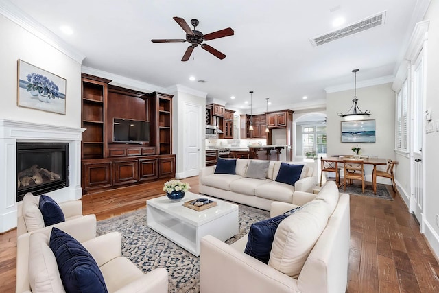 805 Columbia St, Houston, TX 77007 - living room featuring arched walkways, ceiling fan, ornamental molding, dark wood finished floors, and a glass covered fireplace