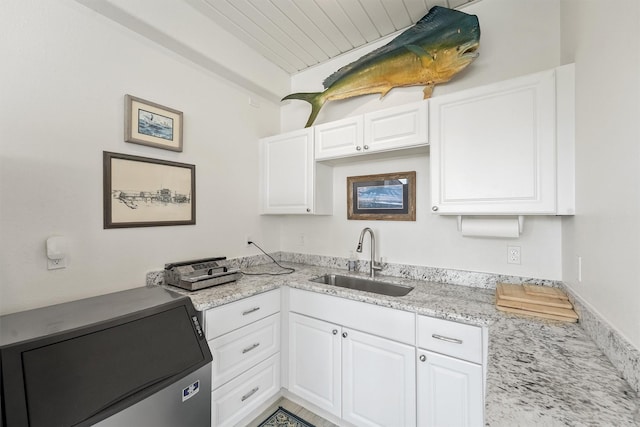 22102 Pecos Dr, Galveston, TX 77554 - kitchen with white cabinetry, light stone countertops, and a sink