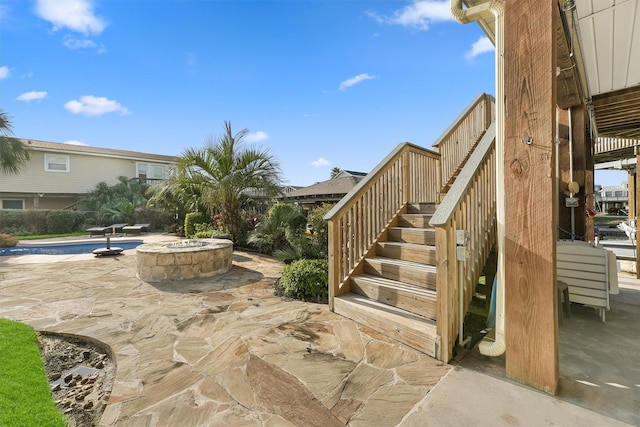 22102 Pecos Dr, Galveston, TX 77554 - view of patio / terrace featuring stairs, an outdoor pool, and an outdoor fire pit