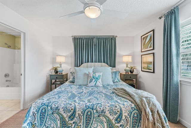 22102 Pecos Dr, Galveston, TX 77554 - bedroom featuring a ceiling fan, baseboards, a textured ceiling, tile patterned floors, and connected bathroom