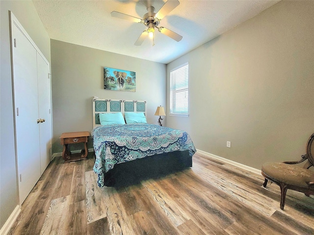 12604 Pegasus Dr, Willis, TX 77318 - bedroom with ceiling fan, a textured ceiling, baseboards, and wood finished floors