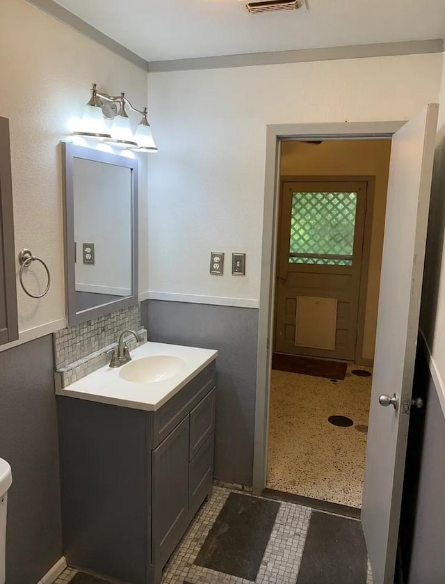half bath featuring visible vents, backsplash, vanity, and toilet