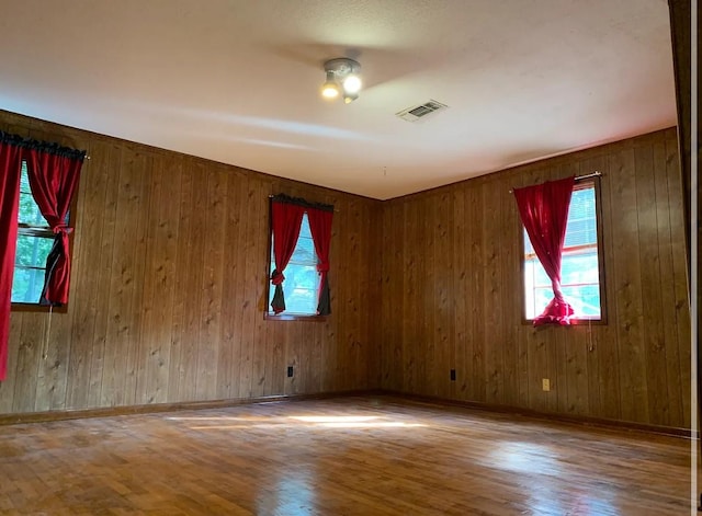 spare room featuring visible vents, baseboards, and wood finished floors