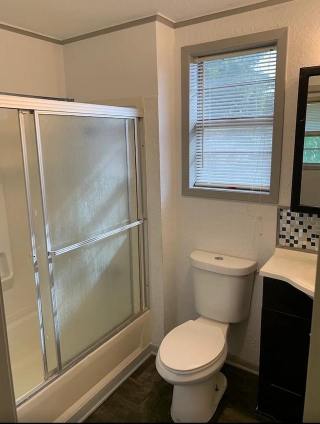 bathroom with toilet, backsplash, baseboards, vanity, and a textured wall