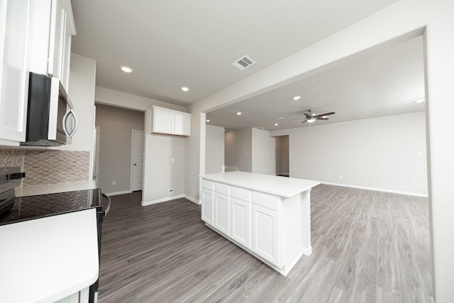 3626 Spy Glass Hill Dr, Montgomery, TX 77356 - kitchen with stainless steel microwave, visible vents, light wood-style flooring, baseboards, and electric stove