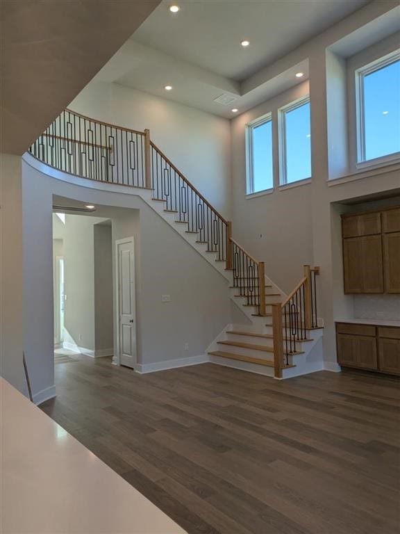 12039 Lake View Blvd, Mont Belvieu, TX 77523 - staircase with wood finished floors, a towering ceiling, baseboards, and recessed lighting