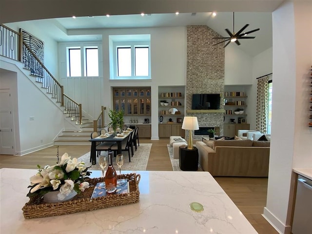 12039 Lake View Blvd, Mont Belvieu, TX 77523 - living room with high vaulted ceiling, stairs, wood finished floors, ceiling fan, and a brick fireplace