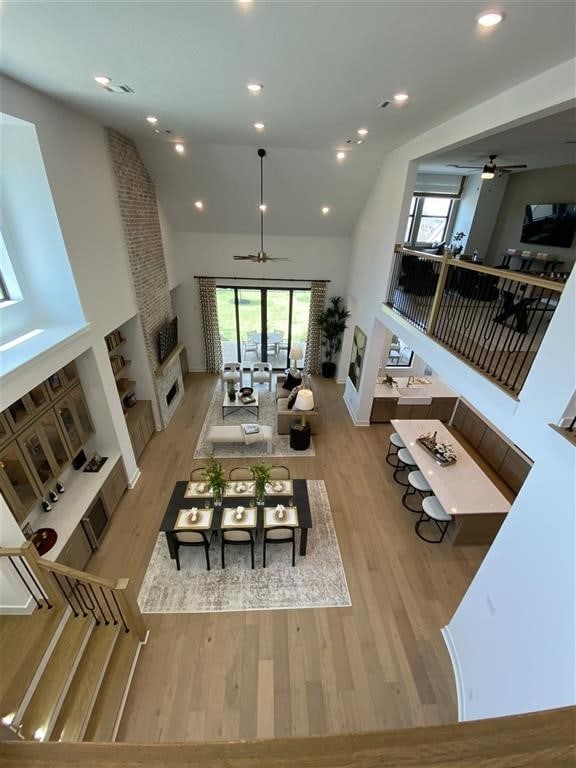 12039 Lake View Blvd, Mont Belvieu, TX 77523 - dining space featuring ceiling fan, a large fireplace, wood finished floors, high vaulted ceiling, and recessed lighting