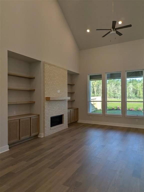 12039 Lake View Blvd, Mont Belvieu, TX 77523 - unfurnished living room featuring high vaulted ceiling, ceiling fan, a fireplace, dark wood-type flooring, and built in features