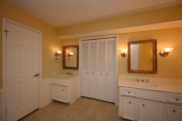 full bath featuring a sink, a closet, and two vanities