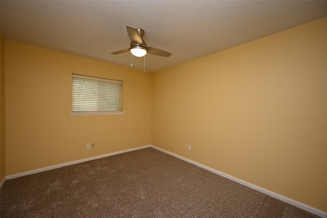unfurnished room with dark carpet, a textured ceiling, ceiling fan, and baseboards