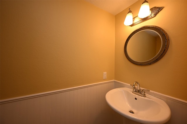 bathroom with a sink and a wainscoted wall