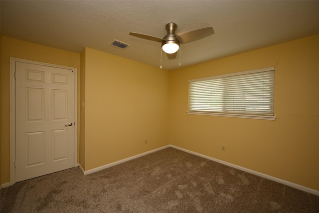 unfurnished room featuring baseboards, a textured ceiling, carpet floors, visible vents, and ceiling fan