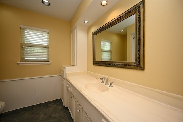 bathroom with toilet, recessed lighting, wainscoting, and vanity