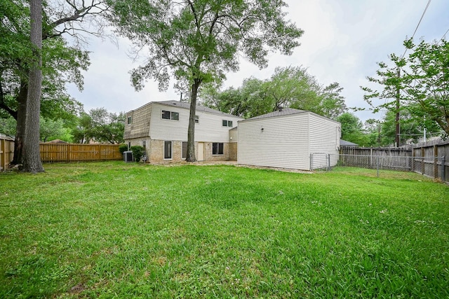 back of house featuring a yard and a fenced backyard