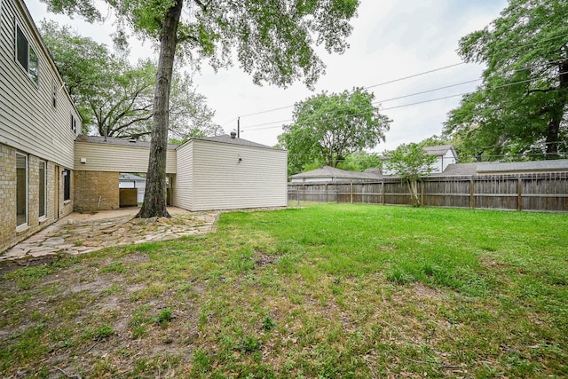 view of yard with an outbuilding, a patio area, and fence