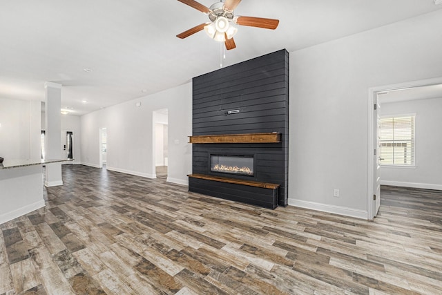 4306 Chadwick Rd, Texas City, TX 77591 - unfurnished living room with wood finished floors, baseboards, a large fireplace, and ceiling fan