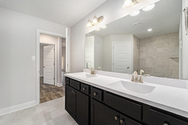 4306 Chadwick Rd, Texas City, TX 77591 - full bath with double vanity, visible vents, a tile shower, and a sink