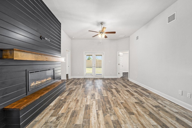 4306 Chadwick Rd, Texas City, TX 77591 - unfurnished living room with visible vents, baseboards, wood finished floors, a glass covered fireplace, and a ceiling fan