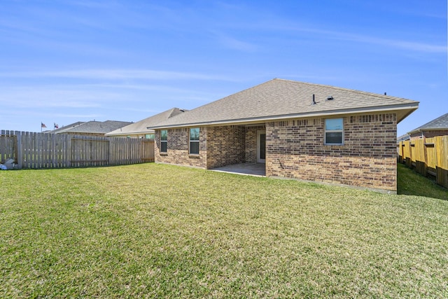 4306 Chadwick Rd, Texas City, TX 77591 - rear view of house featuring a yard, a patio, brick siding, and a fenced backyard