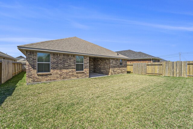 4306 Chadwick Rd, Texas City, TX 77591 - back of house with a yard, a fenced backyard, and brick siding
