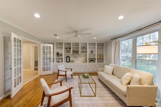 living room featuring a ceiling fan, recessed lighting, french doors, light wood-style floors, and crown molding