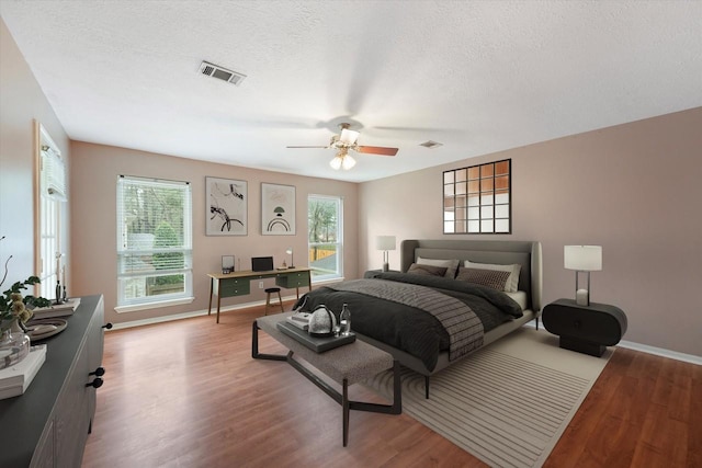 12635 Ivyforest Dr, Cypress, TX 77429 - bedroom featuring baseboards, wood finished floors, visible vents, and a textured ceiling