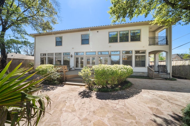 4628 Beech St, Bellaire, TX 77401 - rear view of house with french doors, stucco siding, a balcony, and a wooden deck