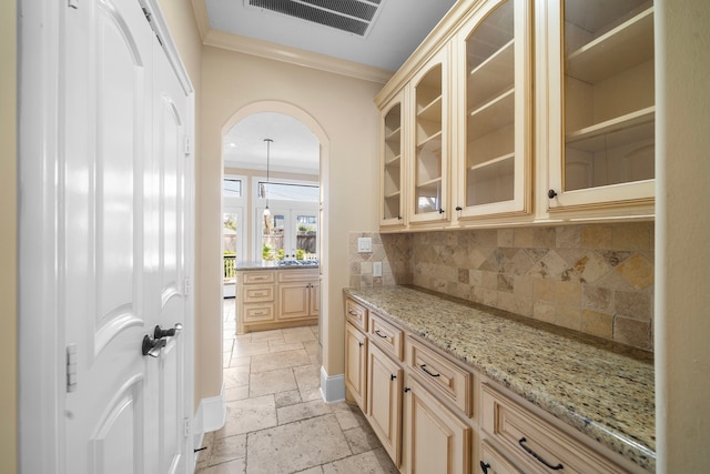 4628 Beech St, Bellaire, TX 77401 - bar area featuring stone tile flooring, crown molding, decorative backsplash, and arched walkways