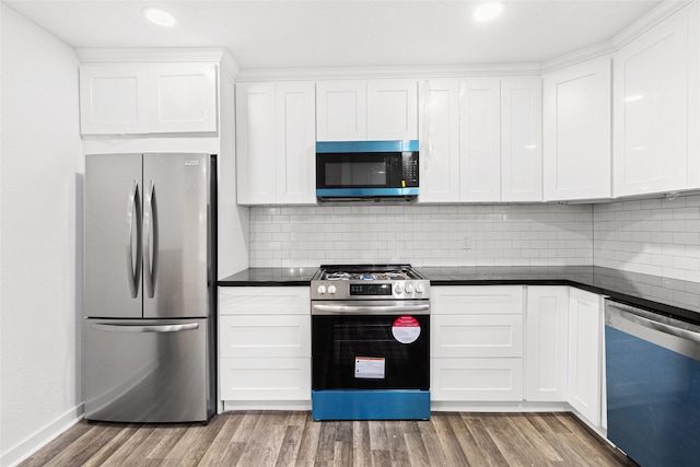 301 Pineland Dr, Trinity, TX 75862 - kitchen with light wood finished floors, white cabinets, appliances with stainless steel finishes, and dark countertops