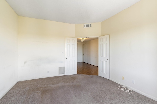 carpeted spare room with baseboards and visible vents