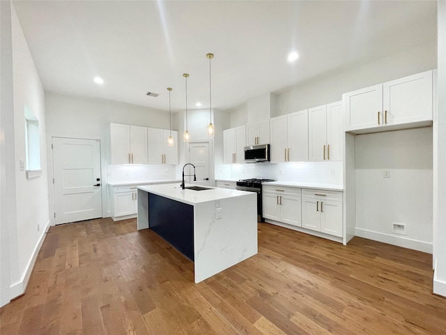 3038 Webster St, Houston, TX 77004 - kitchen with a sink, tasteful backsplash, stainless steel appliances, light wood-style floors, and light countertops