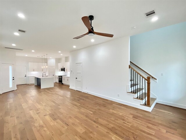 3038 Webster St, Houston, TX 77004 - unfurnished living room with visible vents, light wood-type flooring, and a ceiling fan