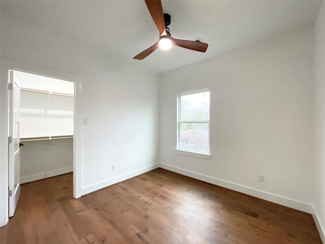3038 Webster St, Houston, TX 77004 - unfurnished bedroom with a spacious closet, a closet, baseboards, and wood finished floors