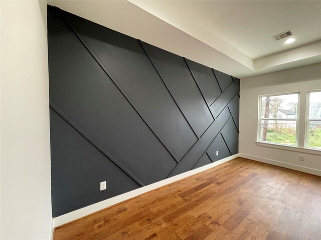 3038 Webster St, Houston, TX 77004 - unfurnished room with visible vents, light wood-style flooring, a tray ceiling, recessed lighting, and baseboards
