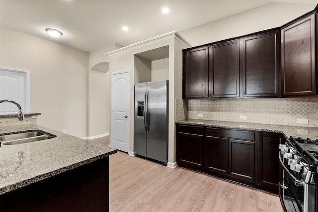 14356 N Summerchase Cir, Willis, TX 77318 - kitchen with stainless steel appliances, light stone counters, a sink, and light wood-type flooring