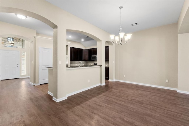 14356 N Summerchase Cir, Willis, TX 77318 - unfurnished living room with arched walkways, a chandelier, dark wood finished floors, and visible vents