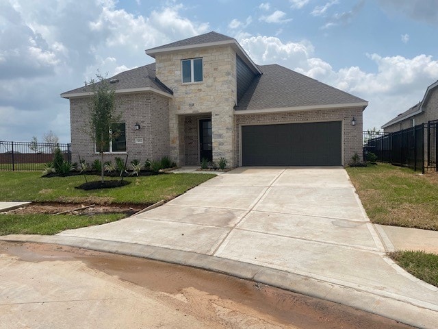 view of front facade featuring fence, brick siding, a front lawn, and a garage