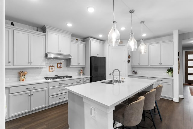 411 Wild Petunia Ct, Montgomery, TX 77316 - kitchen featuring freestanding refrigerator, a sink, under cabinet range hood, stainless steel gas cooktop, and recessed lighting