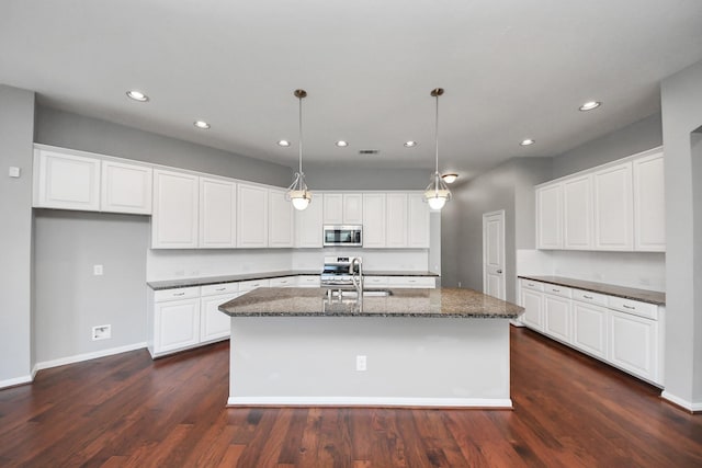 12427 Point Arbor Ct, Tomball, TX 77377 - kitchen with dark stone countertops, a sink, an island with sink, stainless steel appliances, and recessed lighting