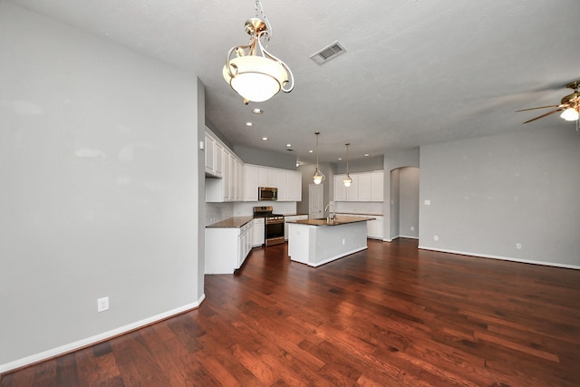12427 Point Arbor Ct, Tomball, TX 77377 - kitchen featuring an island with sink, stainless steel appliances, dark countertops, visible vents, and open floor plan