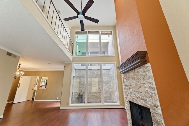 2323 Augusta Dr Unit 36, Houston, TX 77057 - unfurnished living room featuring a towering ceiling, ceiling fan, a stone fireplace, wood finished floors, and baseboards