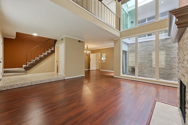 2323 Augusta Dr Unit 36, Houston, TX 77057 - unfurnished living room featuring crown molding, a chandelier, wood finished floors, stairs, and a fireplace