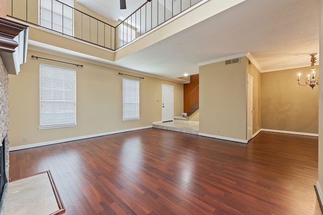 2323 Augusta Dr Unit 36, Houston, TX 77057 - unfurnished living room with a chandelier, hardwood / wood-style floors, a fireplace, stairs, and baseboards
