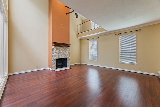 2323 Augusta Dr Unit 36, Houston, TX 77057 - unfurnished living room with wood finished floors, a stone fireplace, baseboards, and a towering ceiling
