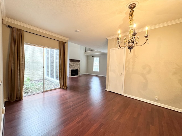 2323 Augusta Dr Unit 36, Houston, TX 77057 - unfurnished living room featuring a chandelier, dark wood-style floors, a fireplace, ornamental molding, and a textured ceiling