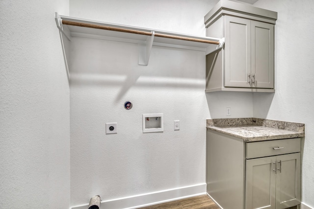 laundry room featuring hookup for a washing machine, wood finished floors, baseboards, hookup for an electric dryer, and cabinet space